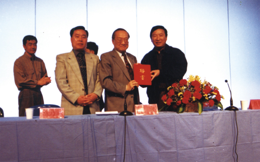 张乃大书记（前左）、肖鲁伟院长（右）向金庸先生颁发聘书，聘为浙江中医学院名誉教授